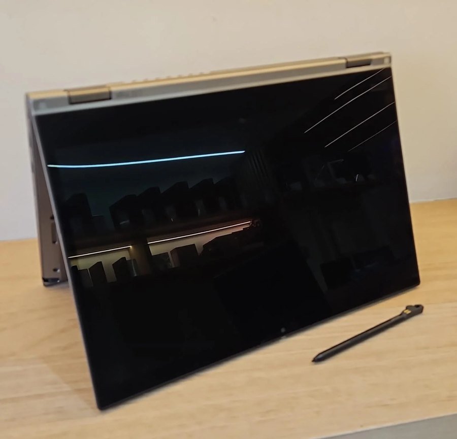 ThinkPad L13 Yoga em modo tenda ao lado da caneta stylus que acompanha o aparelho